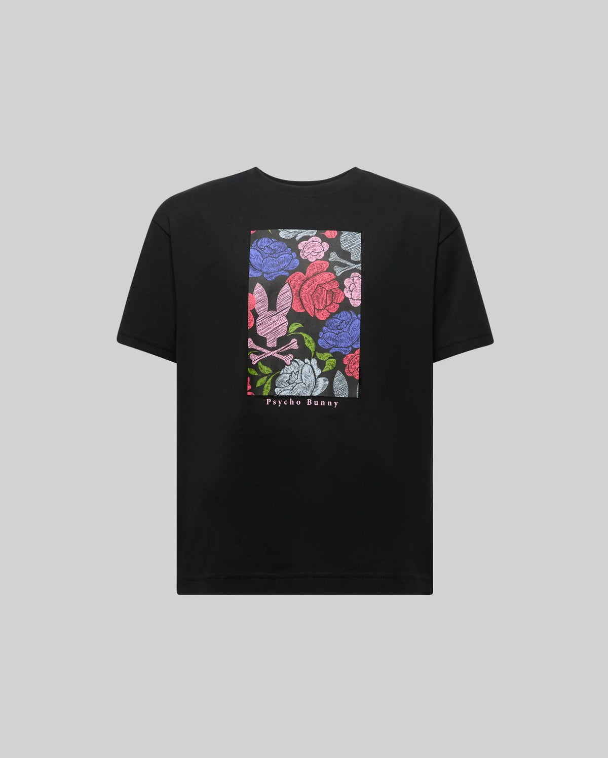 The KIDS ROWEN OVERSIZED TEE (KT0200093) by Psycho Bunny is a black relaxed fit shirt with a colorful floral graphic featuring a pink bunny and skull motif, plus "Psycho Bunny" printed below for an eye-catching look.