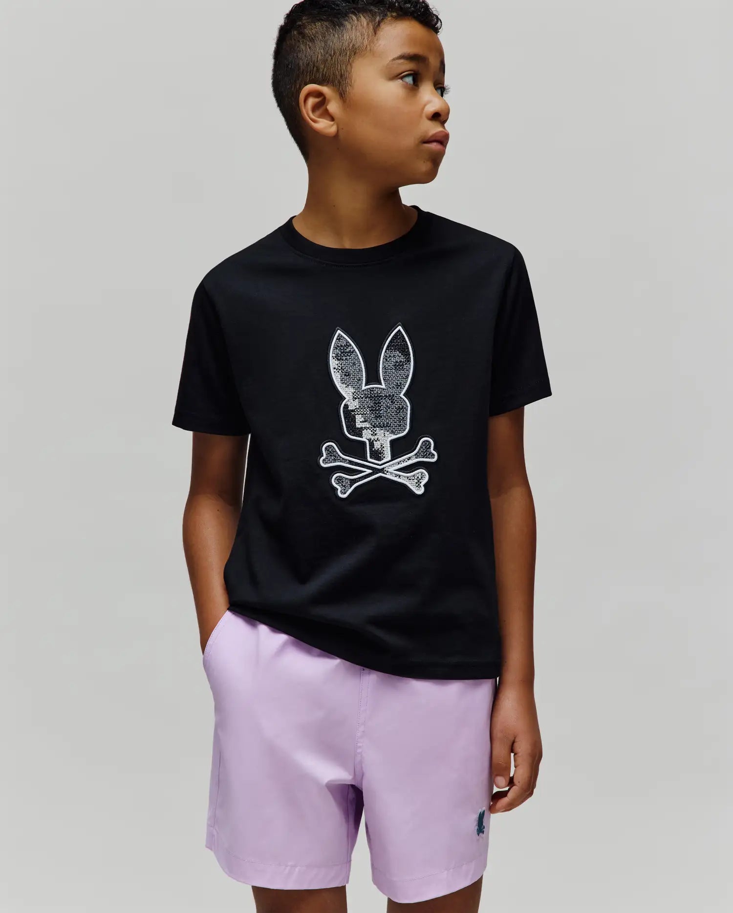 Black Kids Olivier Graphic Tee with a classic fit, featuring a large, textured white and silver Psycho Bunny skull and crossbones graphic on the smooth jersey chest.