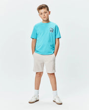 Kids Isaac Relaxed Fit Tee in bright blue jersey with a blue and white abstract bunny skull chest graphic, paired with light beige shorts featuring a small embroidered Psycho Bunny logo on the left thigh. (4)