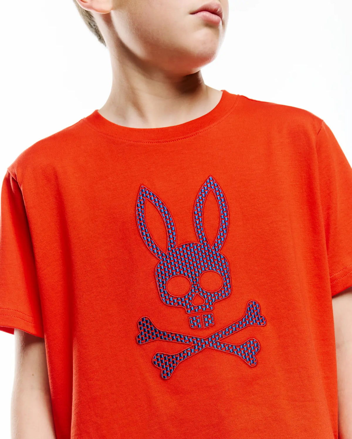 Kids Stan Graphic Tee, vibrant orange jersey knit with a large, central embroidered blue checkered Psycho Bunny skull and crossbones logo, classic fit. (3)