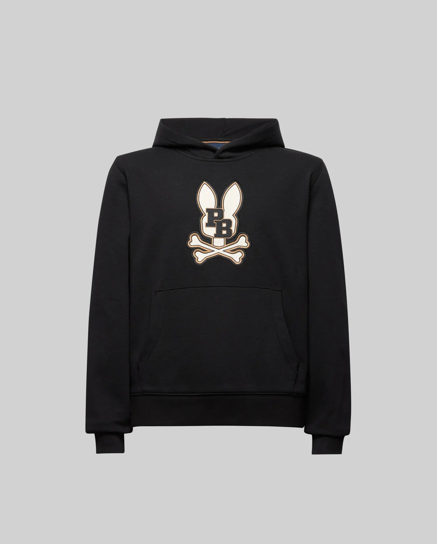 The KIDS WADE CORD PATCH HOODIE (KT0500031) by Psycho Bunny is a black athletic hoodie in a premium cotton blend, with a front pocket and an embroidered Bunny patch on the chest, shown against a plain gray background.