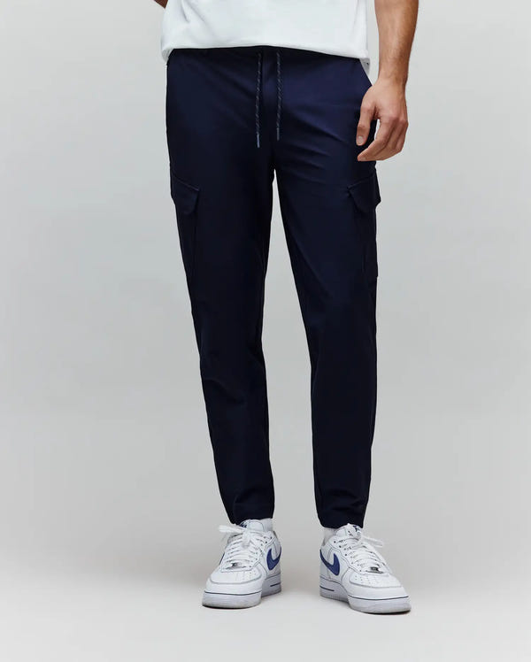 Mens Luka Cargo Pant, a premium navy streetwear pant with a relaxed tapered fit, smooth performance fabric, adjustable drawstring waist with flecked cord, and functional side cargo pockets.
