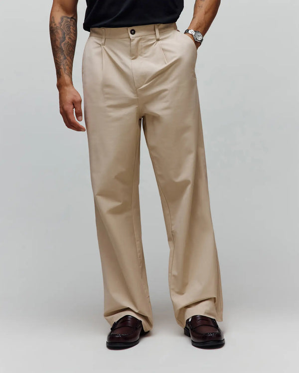 Malik Wide Leg Pant in khaki smooth cotton twill, featuring a relaxed wide leg fit, single front pleats, and a subtle embroidered Psycho Bunny skull logo on the hip.