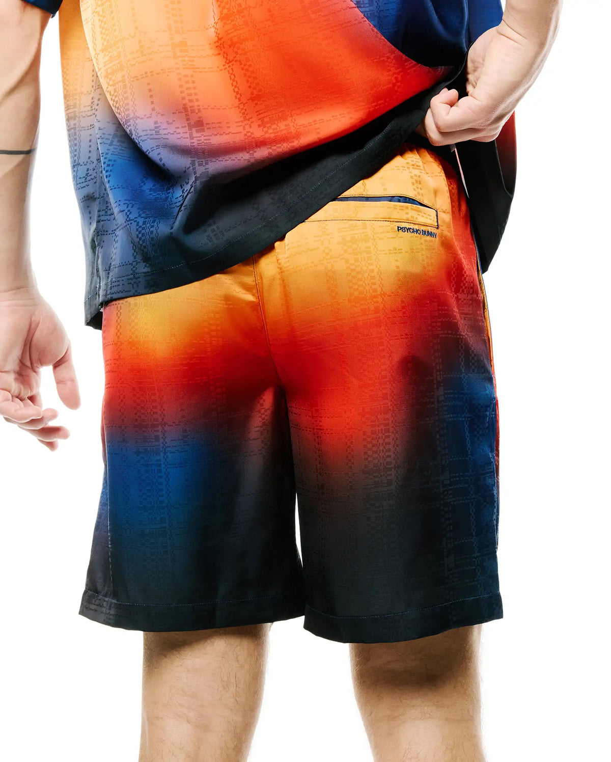 Mens Zander Jacquard Short, a relaxed fit short with a vibrant orange-red to deep blue gradient, featuring a subtle geometric jacquard pattern and a small Psycho Bunny text logo on the back right pocket. (3)