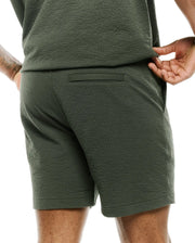 Mens Arlen Seersucker Short in dark olive green, featuring a classic fit, distinctive puckered seersucker texture, a subtle back welt pocket, and practical side pockets. (2)