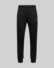 The Psycho Bunny MENS AUGUSTE JOGGER - MB0800015 in black features 100% cotton, an elastic waistband with drawstring, cuffed ankles, and a subtle chenille patch emblem on the left thigh, shown on a light gray background.