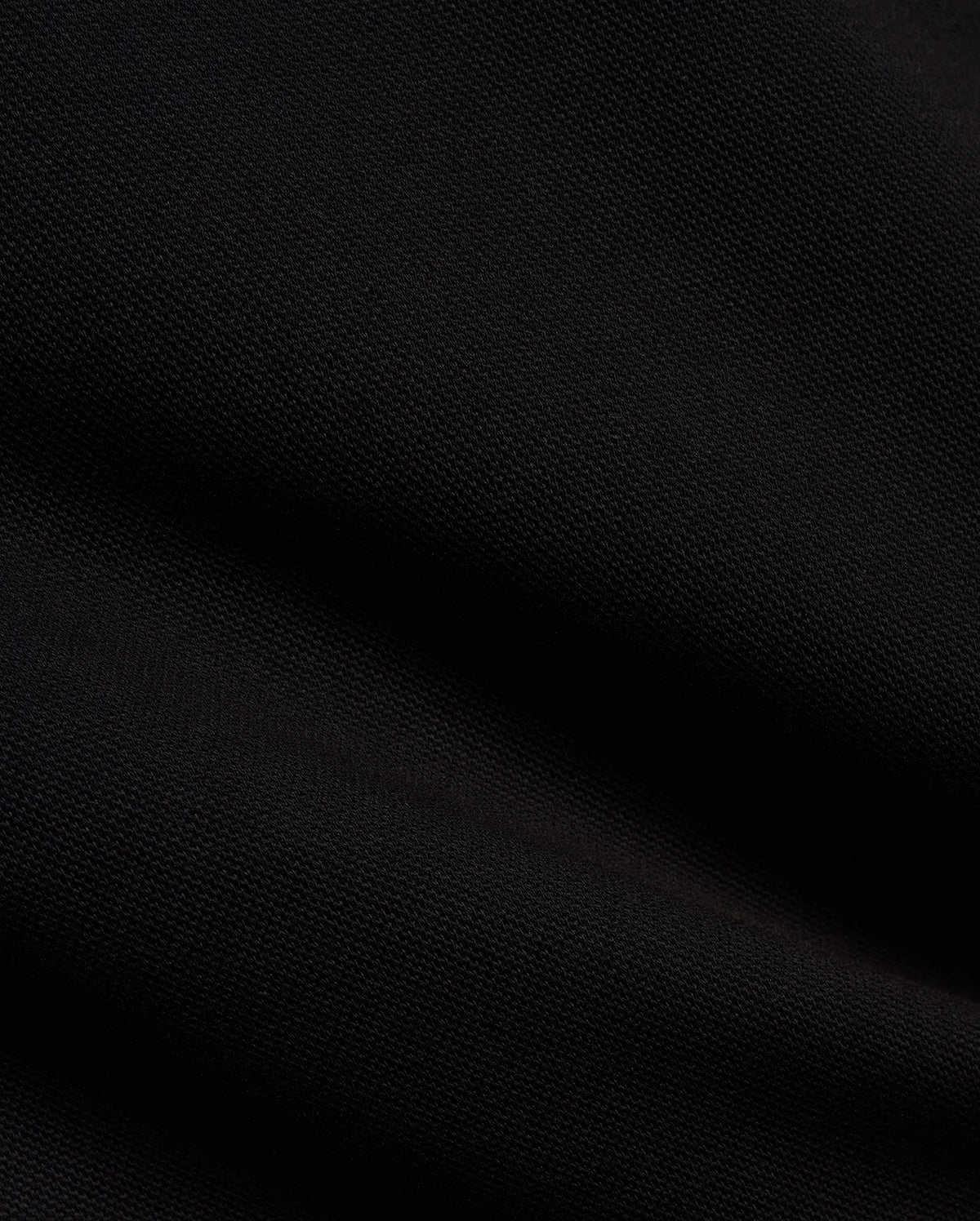 Men's Jacques Pique Track Pants in deep black, showcasing the refined, breathable pique knit fabric texture with subtle diagonal ribbing and soft folds, characteristic of premium Psycho Bunny streetwear. (6)