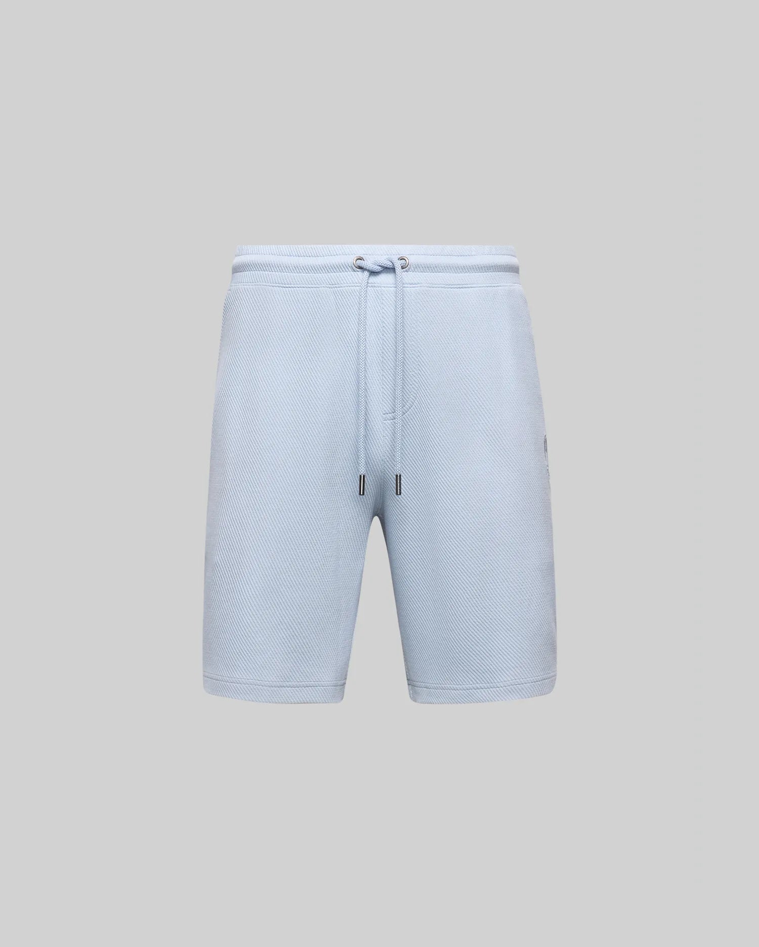 The Psycho Bunny MENS KAI SWEATSHORT (MB0900015) are light blue twill men’s shorts with an elastic waistband, drawstring ties with metal-capped ends, and a minimalistic design without visible logos, shown on a plain grey background.