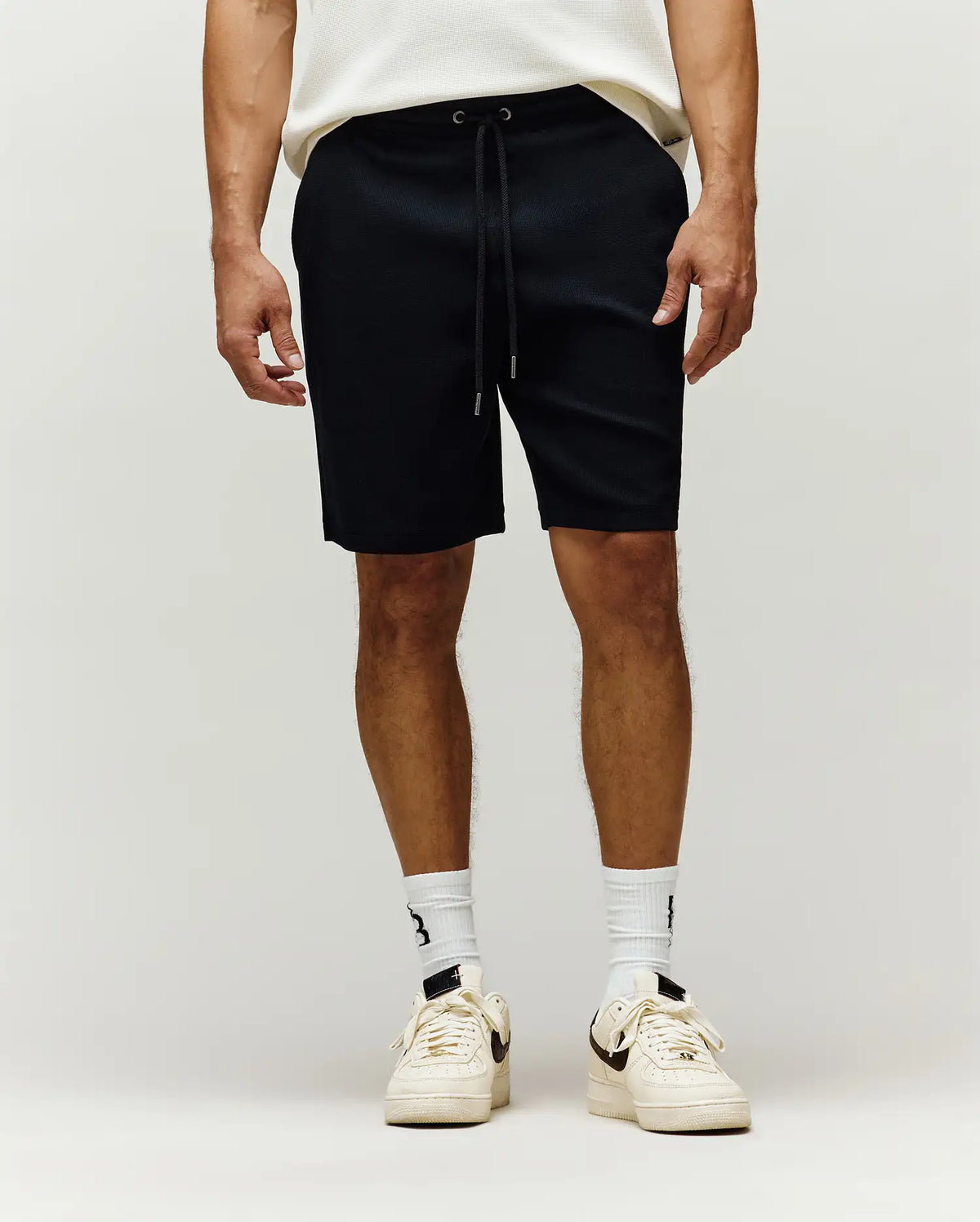 Mens Maxton Waffle Sweatshort in black, featuring a relaxed fit, textured waffle knit fabric, and an adjustable drawstring waist with sleek metal tips.