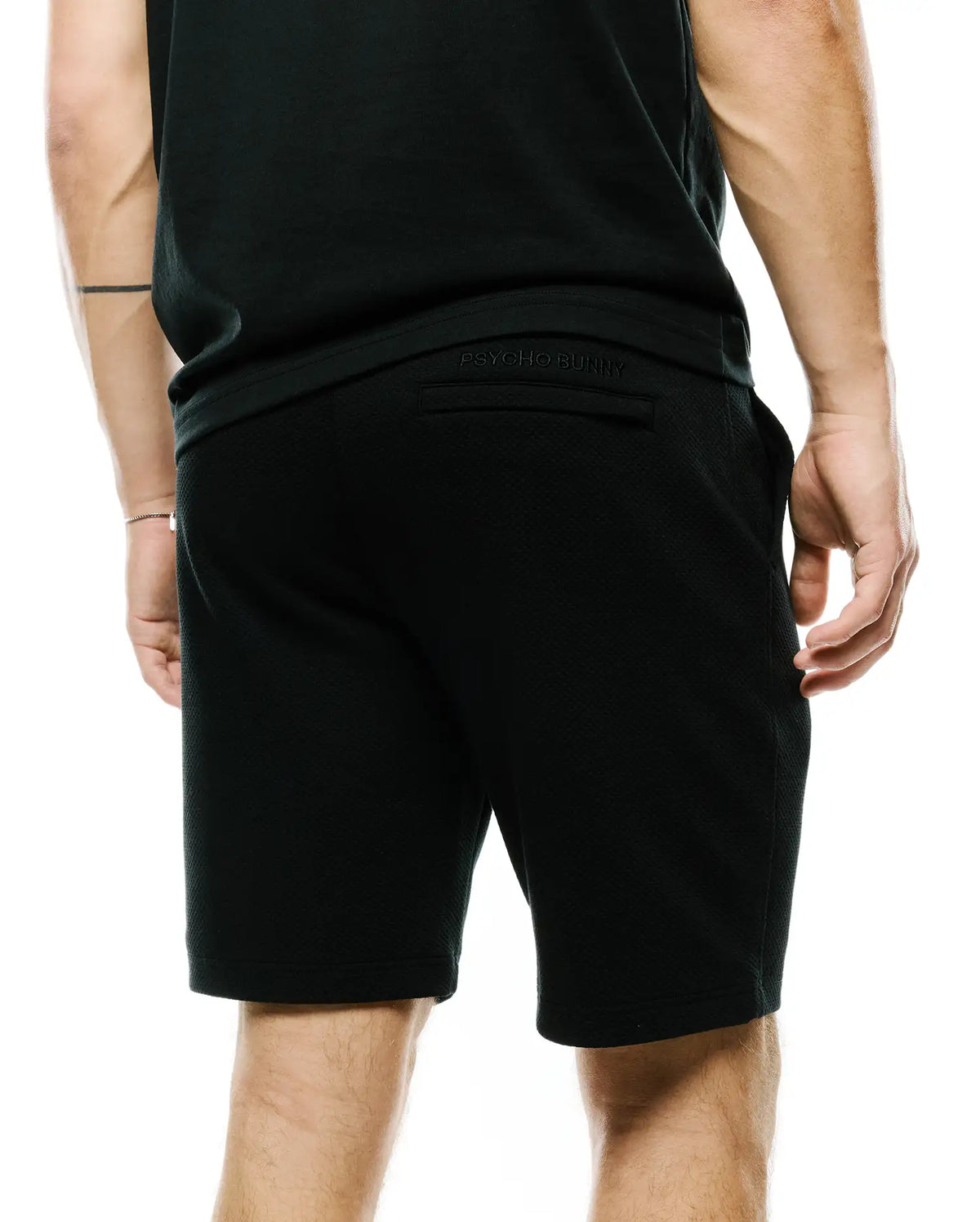 Mens Marc Textured Short, a black, relaxed-fit short crafted from a distinctive textured knit fabric, featuring subtle tonal embroidered Psycho Bunny branding on the back waistband. (3)