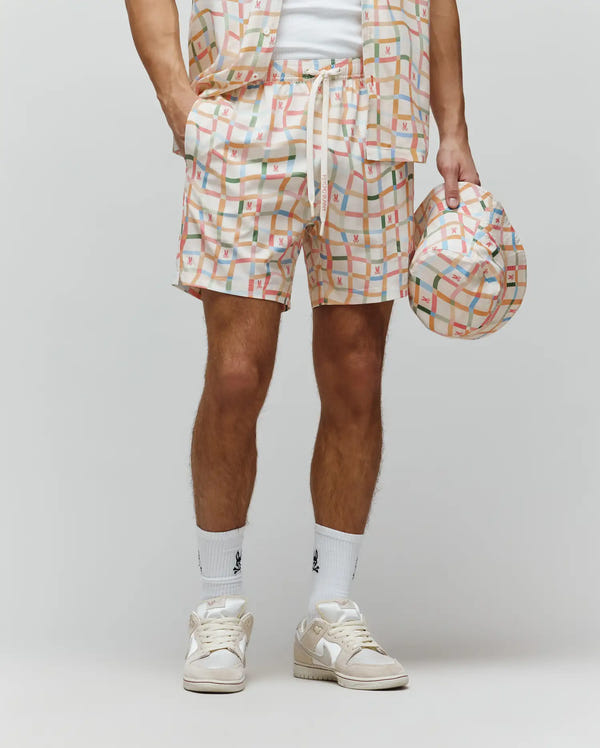 Mens Atlas Swim Trunk in cream with a vibrant multicolor plaid pattern, featuring small repeated Psycho Bunny skull logos and PSYCHO BUNNY text on the drawstring. Relaxed fit, smooth quick-dry fabric.