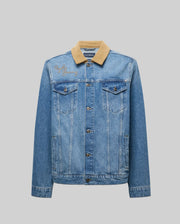 The Psycho Bunny MENS WADE DENIM TRUCKER JACKET - MO1100015 features blue denim, a tan corduroy collar, button closure, chest and side pockets, plus a bunny patch on the left shoulder, shown against a plain gray background.