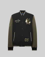 The Psycho Bunny MENS AUG﻿USTE KNIT BOMBER (MO1100050) is a black and olive varsity jacket with front snap buttons, embroidered text, chenille bunny and flower patches, number "05" on one side, and "53" on the sleeve; shown on a gray background.