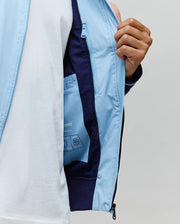Mens Aldrin Bomber in sky blue with navy lining, ribbed cuffs, and a full-zip closure featuring a small bunny skull logo pull. Internal pocket shows Psycho Bunny branding.