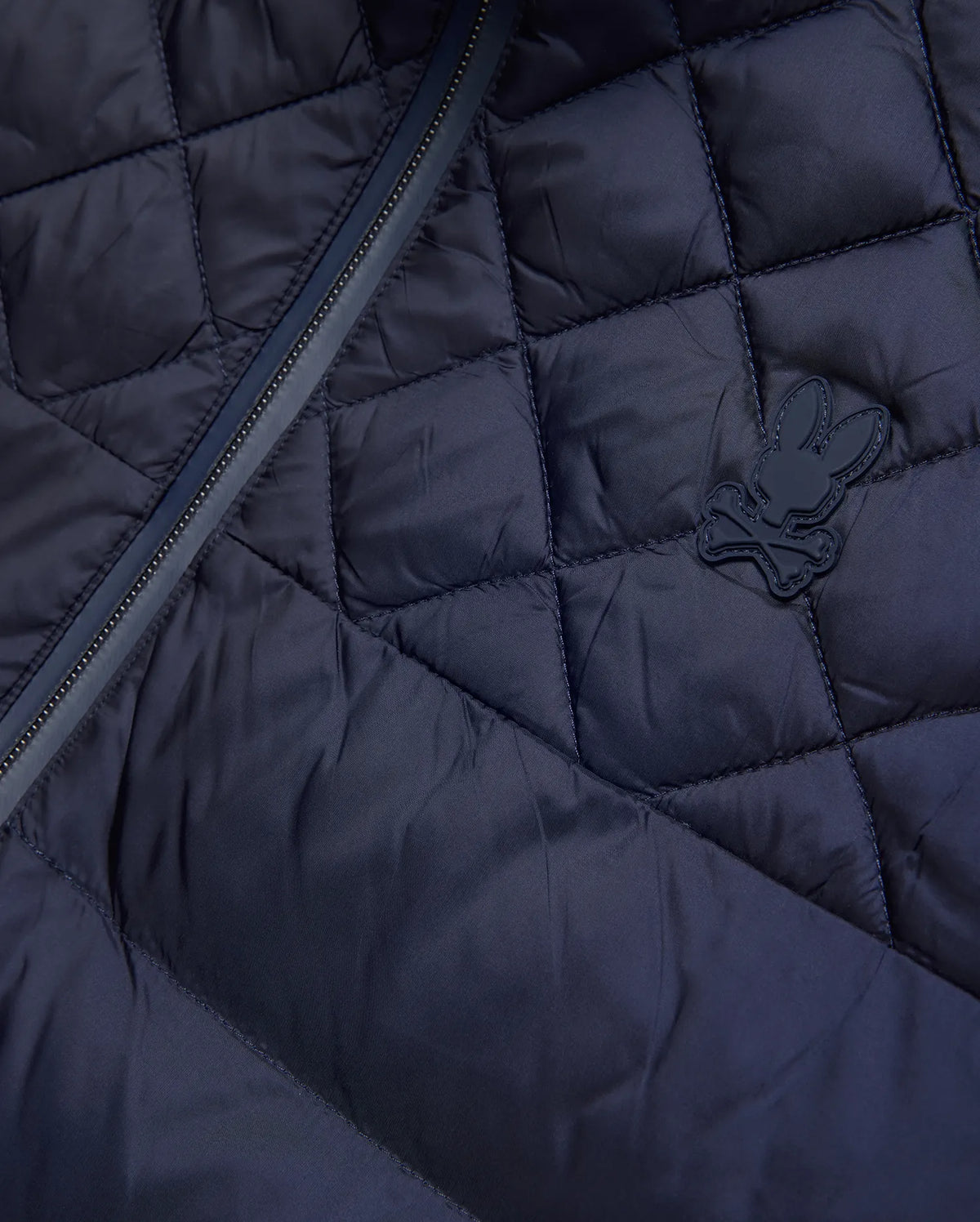 Mens Emerik Puffer Jacket, a navy quilted puffer jacket crafted from smooth nylon, featuring a dark zipper and a small, rubberized Psycho Bunny skull logo on the chest. (6)