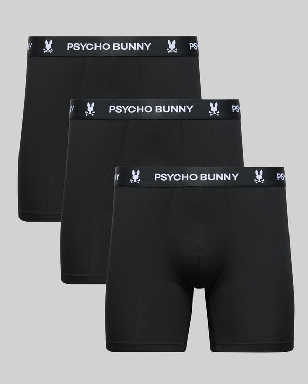 Three pairs of Psycho Bunny MENS 3 PACK BOXER BRIEF (MO1400006) are shown in a row, made from a soft cotton-modal blend with black waistbands featuring "PSYCHO BUNNY" and the bunny logo in white against a light gray background.