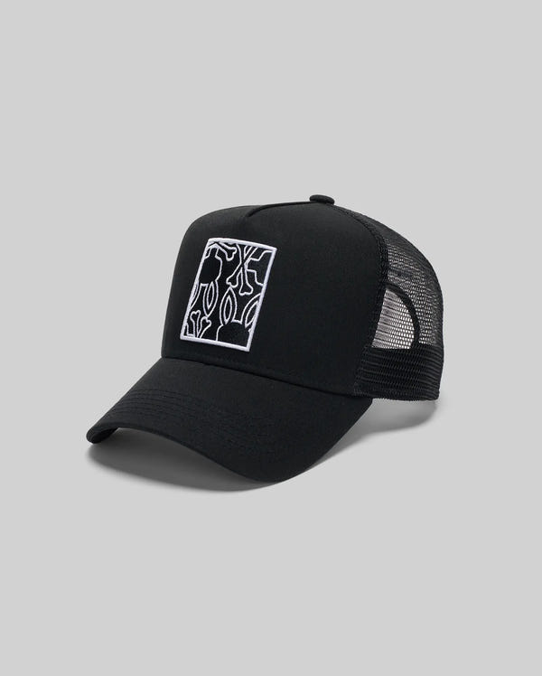 The Psycho Bunny MENS GLENN TRUCKER CAP (MO1500004) features a black design with a rectangular abstract white line and subtle bunny logo on the front, mesh back, curved brim, and snapback closure, shown on a plain gray background.