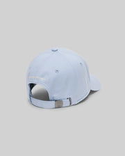 The Psycho Bunny MENS GRANT BASEBALL CAP - MO1500﻿037 is a light blue cotton cap shown from the back, with an adjustable metal clasp backstrap and "PSYCHO BUNNY" embroidered above the opening. The background is plain light gray.