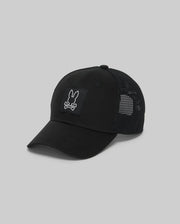 The Psycho Bunny MENS DARIO TRUCKER CAP (MO1500044) is a black cotton twill cap with a mesh back, adjustable snap-back, and features a front patch of a rabbit head above crossed bones on a plain gray background.