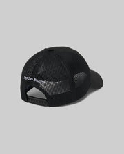 The Psycho Bunny MENS DARIO TRUCKER CAP (MO1500044) is shown from the back, with a breathable black mesh design, adjustable snap closure, and "Psycho Bunny" embroidered in white above the opening.