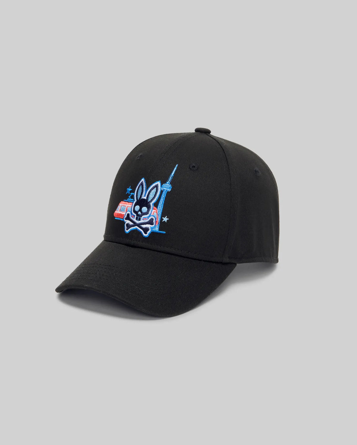 The Psycho Bunny MENS TORONTO BASEBALL CAP (MO1500049) has an adjustable back, a black front with embroidered Bunny graphic, crossed bones, city tower and red-blue building. Light gray background for a modern look.