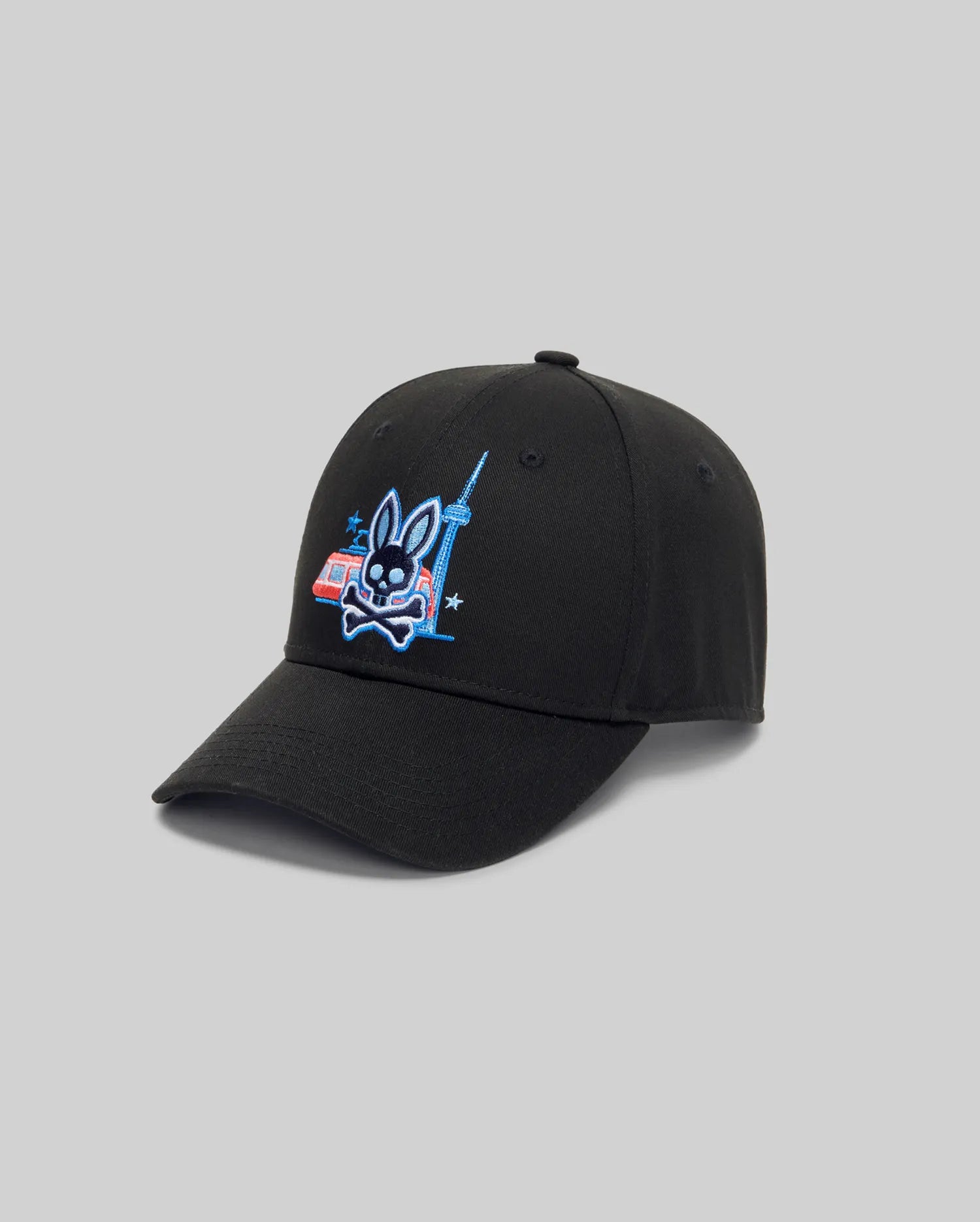 The Psycho Bunny MENS TORONTO BASEBALL CAP (MO1500049) has an adjustable back, a black front with embroidered Bunny graphic, crossed bones, city tower and red-blue building. Light gray background for a modern look.