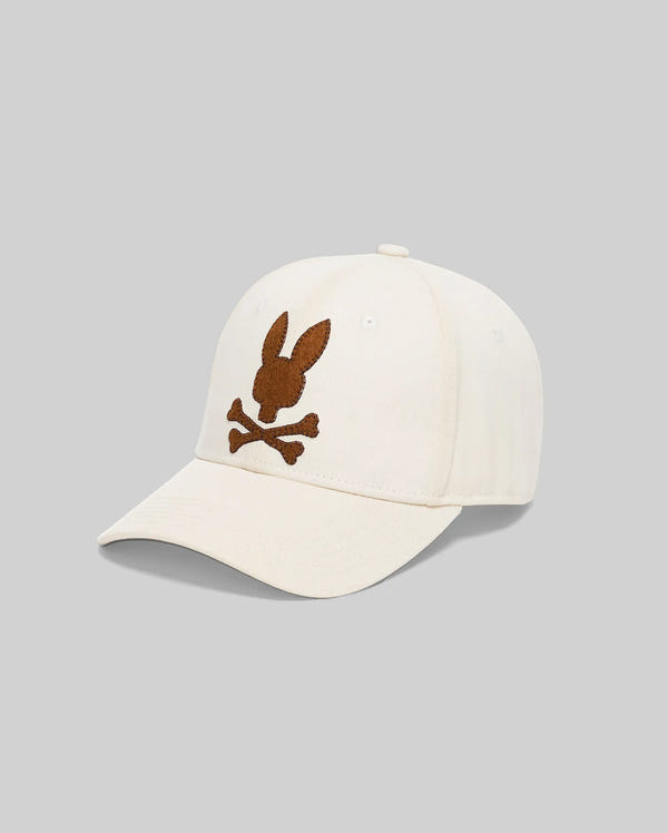 Mens Gage Felted Baseball Cap in cream, featuring a large, central brown felted Psycho Bunny skull logo embroidered on the front.