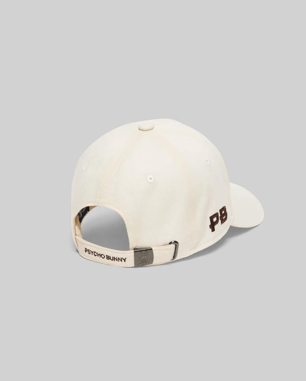 Mens Gage Felted Baseball Cap in cream, featuring an embroidered brown PB logo on the side, Psycho Bunny text on the back strap, and a metallic bunny skull buckle.