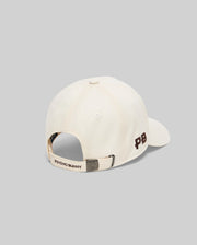 Mens Gage Felted Baseball Cap in cream, featuring an embroidered brown PB logo on the side, Psycho Bunny text on the back strap, and a metallic bunny skull buckle.