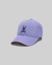 The MENS OFFICIAL US OPEN AVERY NET SPORT CAP by Psycho Bunny is a lavender baseball cap with a perforated back, curved brim with pink accent, light gray background, and features the black Psycho Bunny logo with crossbones on the front.