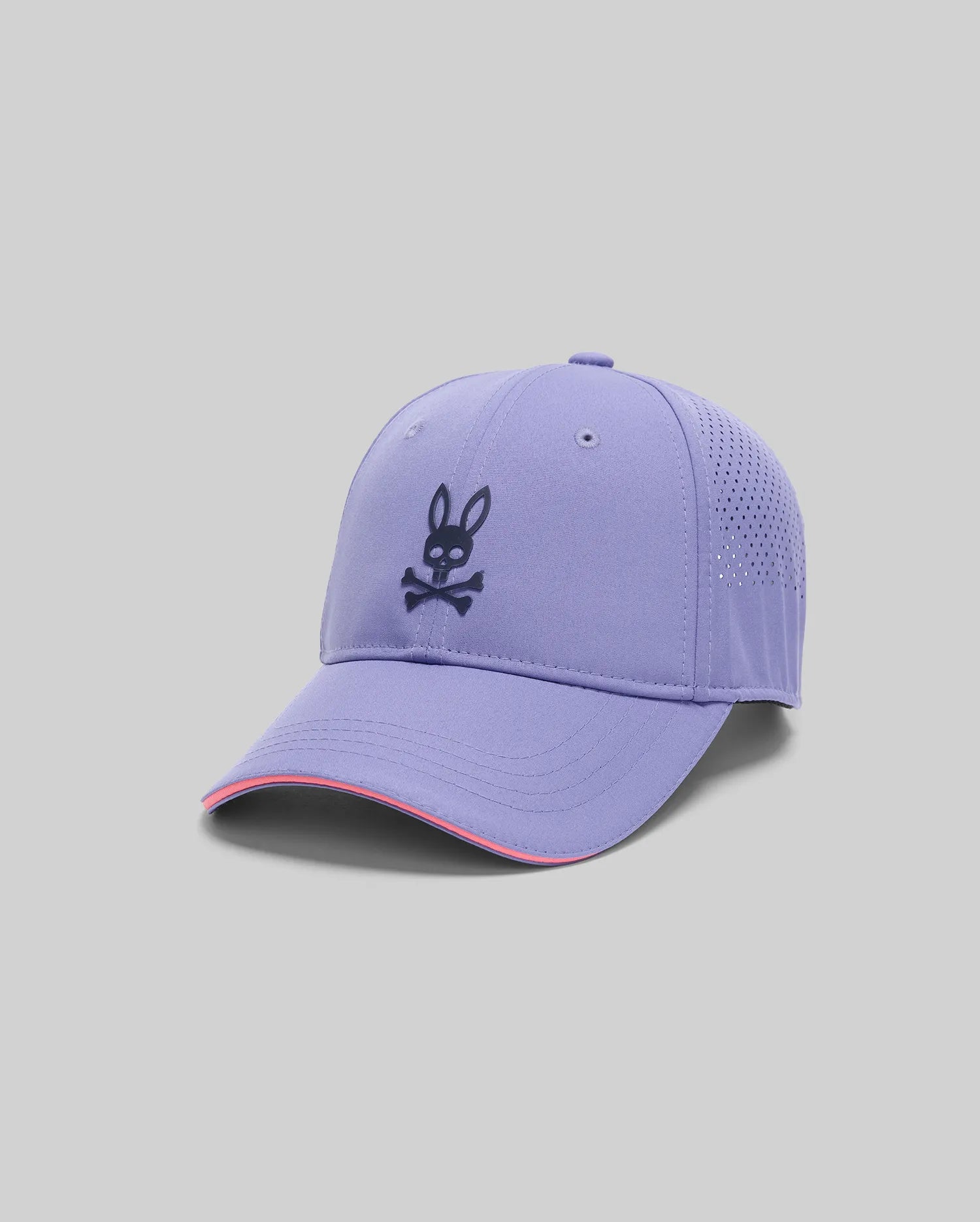 The MENS OFFICIAL US OPEN AVERY NET SPORT CAP by Psycho Bunny is a lavender baseball cap with a perforated back, curved brim with pink accent, light gray background, and features the black Psycho Bunny logo with crossbones on the front.