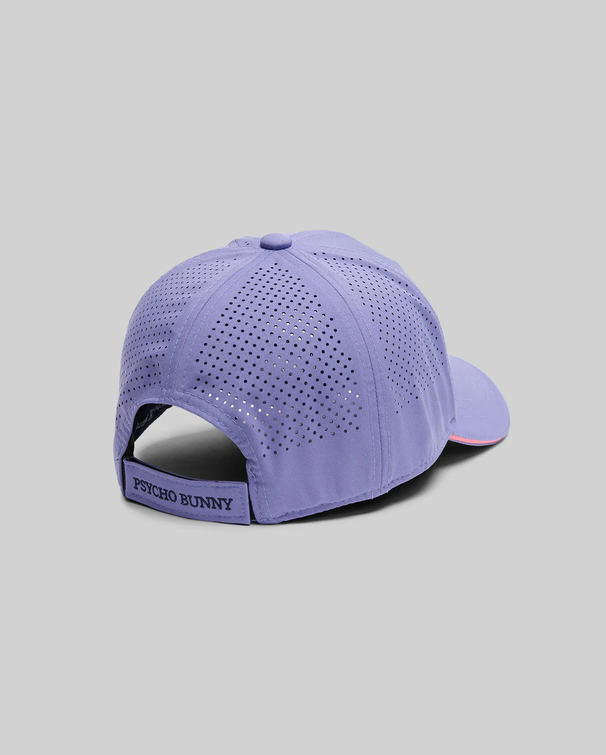 The MENS OFFICIAL US OPEN AVERY NET SPORT CAP (MO1500086) by Psycho Bunny, shown against a gray background, features lavender color, ventilated perforations, and an adjustable strap with a branded label for a breathable sport cap style.