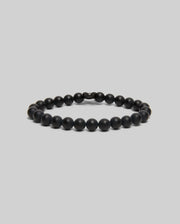 The Psycho Bunny MENS BUNNY BEAD BRACELET - MO1700023 features matte black, round beads arranged in a circle, showcased on a light gray background—an elegant touch for polished style.