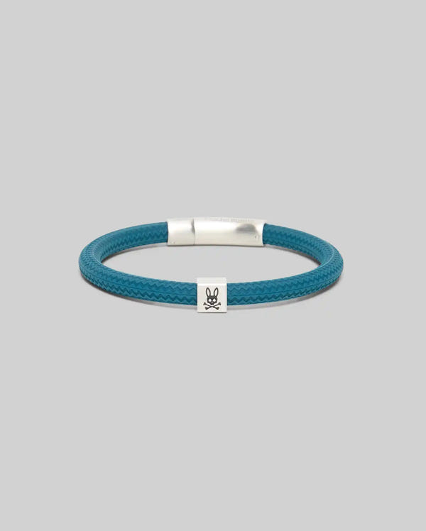 Mens Silicone Bracelet in deep teal, featuring a textured chevron-patterned band, a sleek silver metallic clasp, and a small silver charm with the iconic black Psycho Bunny skull logo.