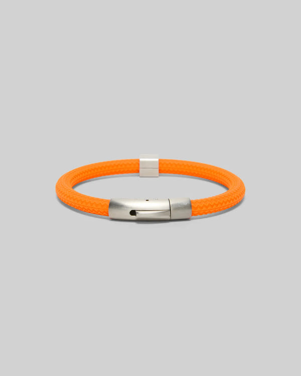 The Psycho Bunny MENS SILICONE BRACELET (MO1700025) features an orange braided design with a silver magnetic clasp, shown on a light gray background.