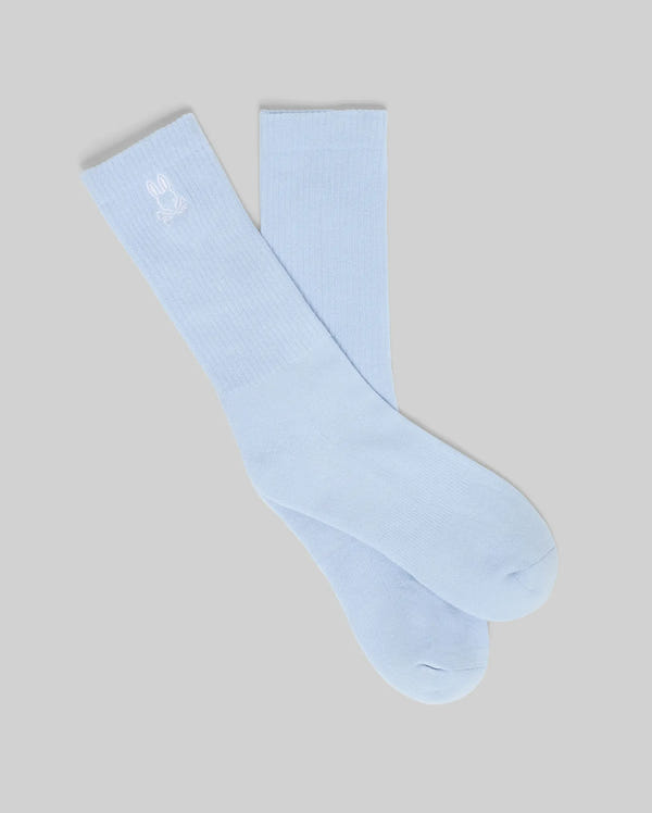 The MENS NEW CLASSIC SPORT SOCK - MO2200001 by Psycho Bunny is a light blue stretch cotton blend sock with a small white embroidered bunny logo near the top, shown on a plain gray background.