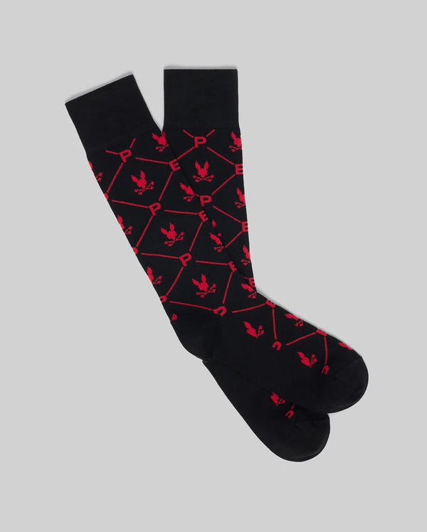The Psycho Bunny MENS 2 PACK DRESS SOCK - MO2200005 features black knee-high socks with a red hexagonal pattern, "P" designs, and small eagle icons, shown on a light gray background.