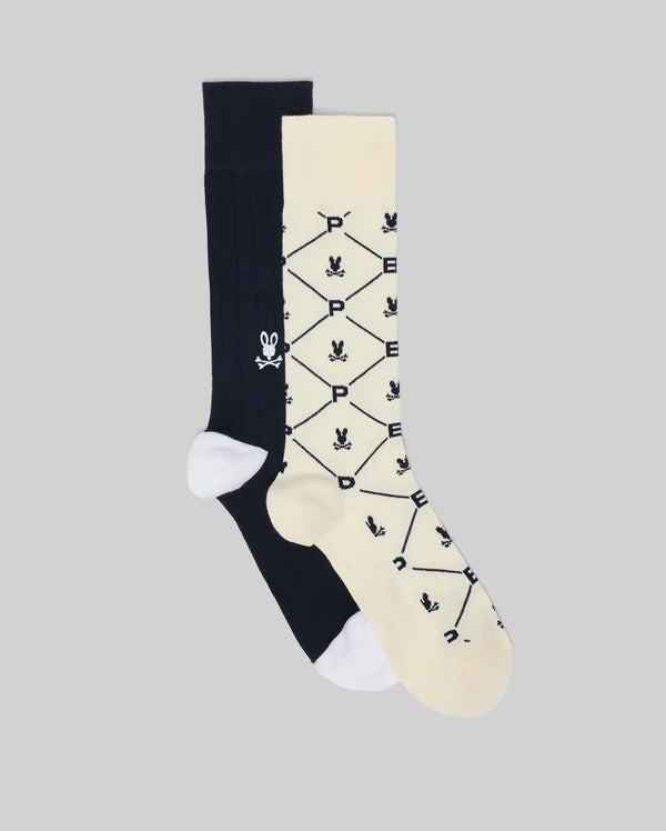 The Psycho Bunny MENS 2 PACK DRESS SOCK - MO2200005 features one solid black sock with a white skull and crossbones, and a cream sock with black geometric patterns, skulls, and “P”, both in soft Pima cotton with white toes and heels.
