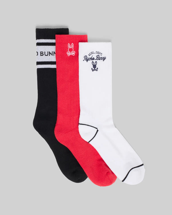 The Psycho Bunny MENS 3 PACK SPORT SOCK (MO2200008) includes three crew socks—black with stripes, red with a small logo, and white with Psycho Bunny text and logo on the cuff—crafted from soft Pima cotton, nylon, and spandex.