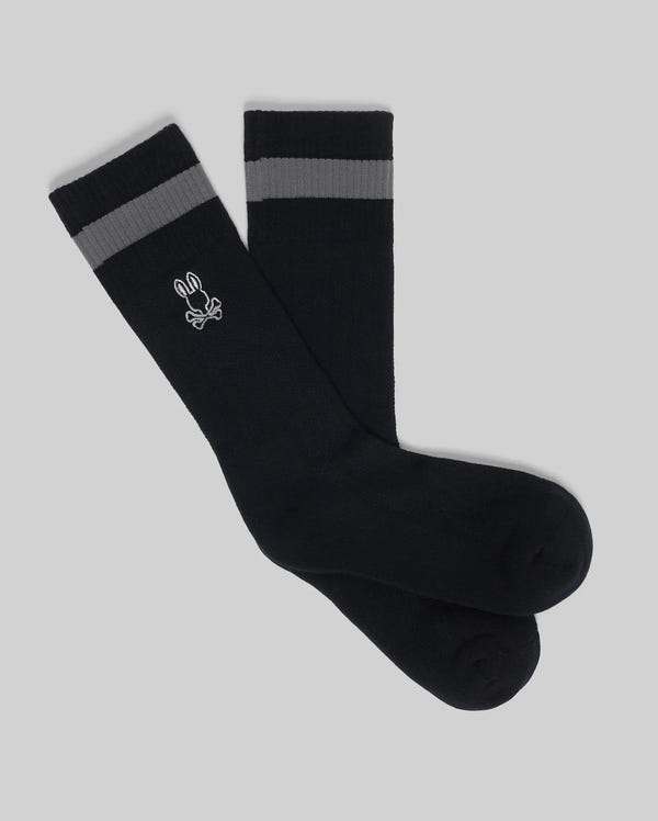 The Psycho Bunny MENS TEXTURED STITCH SPORT SOCK (MO2200017) is a black sock with gray stripes near the top and a white bunny logo on the side, featuring a textured stitch pattern. Displayed on a plain gray background.