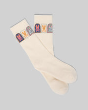 The Psycho Bunny MENS SUNDEW GRAPHIC SPORT SOCK (MO2200020) features cream-colored Pima cotton with colorful cartoon bunny graphics in squares near the top, shown laid flat on a plain gray background.