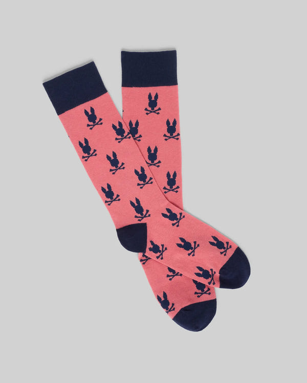 The Psycho Bunny MENS ALL OVER BUNNY DRESS SOCK (MO2200022) features a pink colorblock design with navy blue heels, toes, and cuffs, plus an all-over pattern of navy bunnies with spread ears.