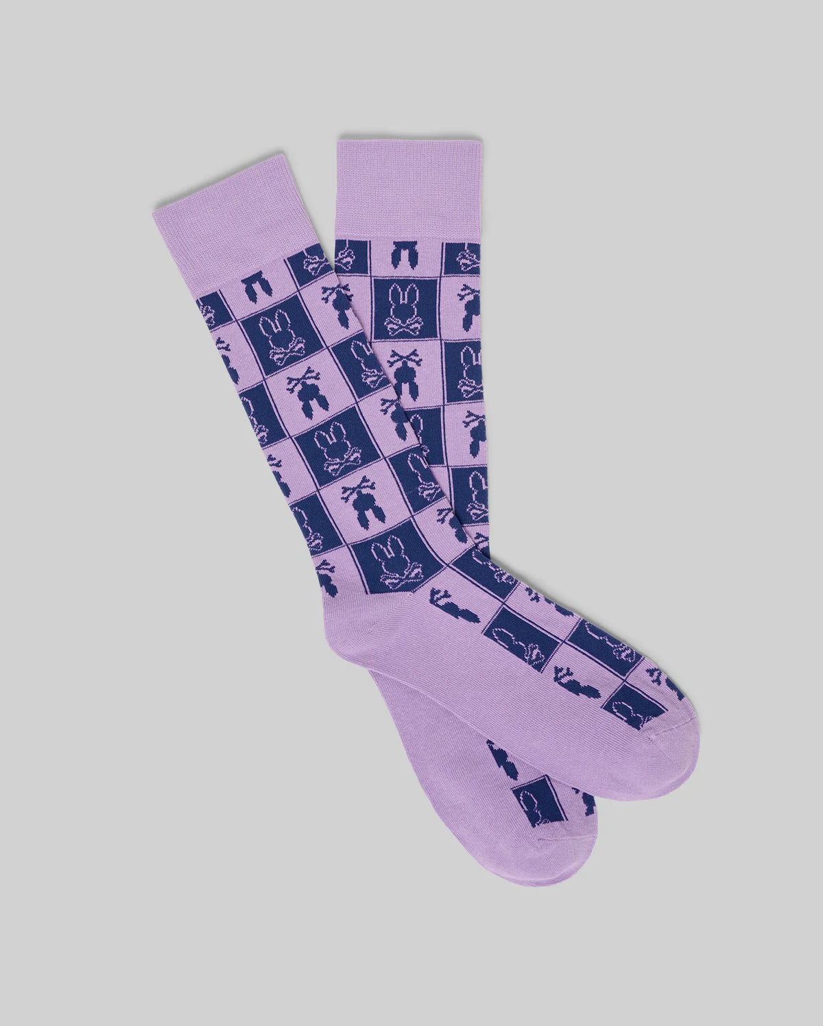 Mens All Over Square Bunny Dress Sock in lavender with a dark blue checkerboard pattern featuring the iconic Psycho Bunny skull logo and various bunny-themed graphics throughout.
