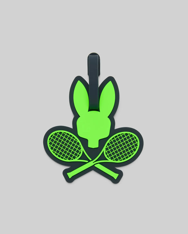 The Psycho Bunny MENS RACKET BUNNY LUGGAGE TAG (MO2400003) features a green bunny head above crossed tennis rackets on a gray background, adding a sporty touch to your luggage.