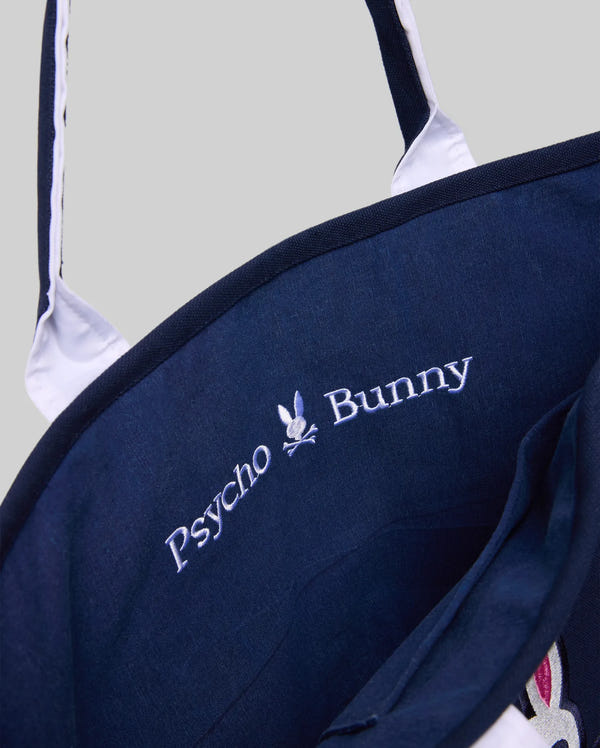 Close-up of the Psycho Bunny MENS CANVAS TOTE BAG - MO2400016 in navy with white handles, featuring embroidered "Psycho Bunny" text and a bunny skull logo, ideal for adding premium athleisure style to your farmer's market trips.