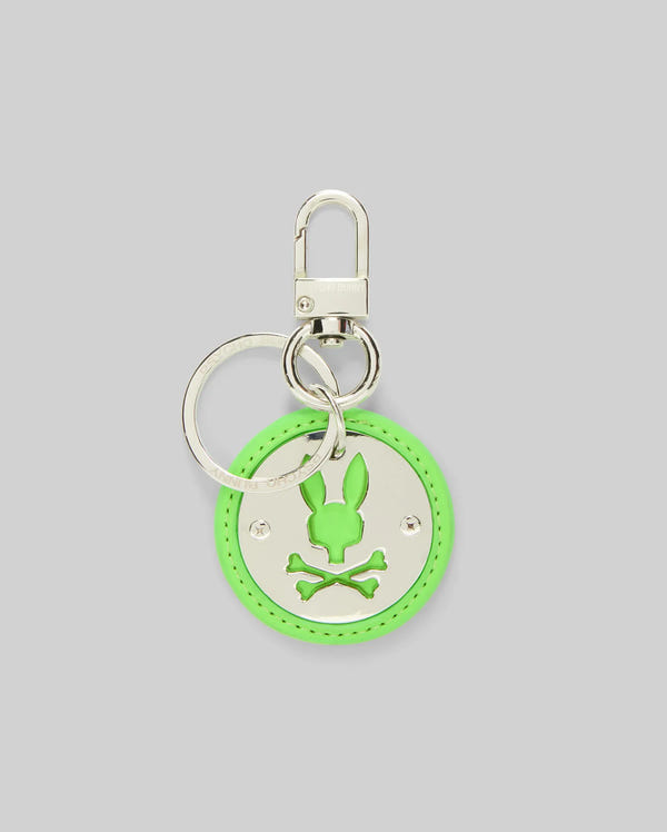 The Psycho Bunny DISC KEYCHAIN - MO2400020 features a silver disc and a round neon green leather charm with a bunny head above crossed bones, adding a playful twist to the classic skull and crossbones motif.