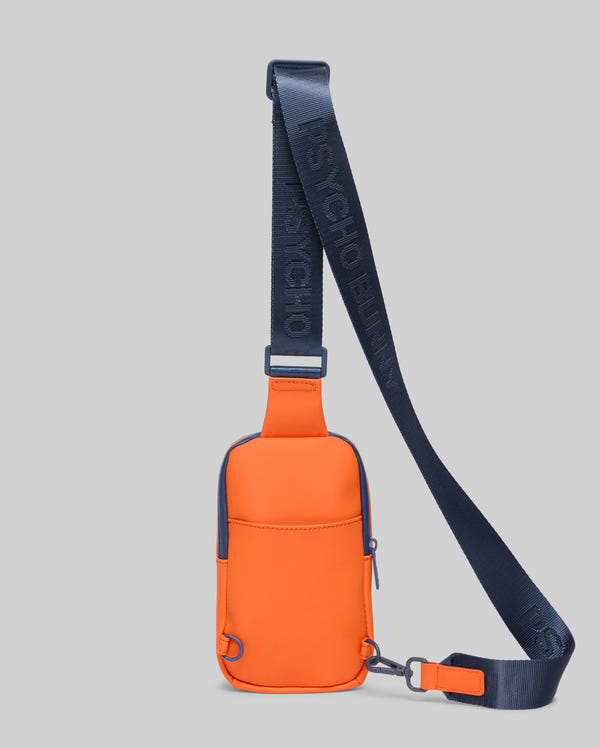 Mens Rubberized Crossbody in vibrant orange with navy blue accents, featuring a smooth rubberized texture, a front zipper pocket, and a wide navy strap with repeated Psycho Bunny text branding.