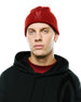 Red ribbed knit Men's Leighton Merino Beanie with tonal embroidered Psycho Bunny skull logo, paired with a black relaxed fit French terry hoodie featuring a subtle graphic print and a red crewneck t-shirt.