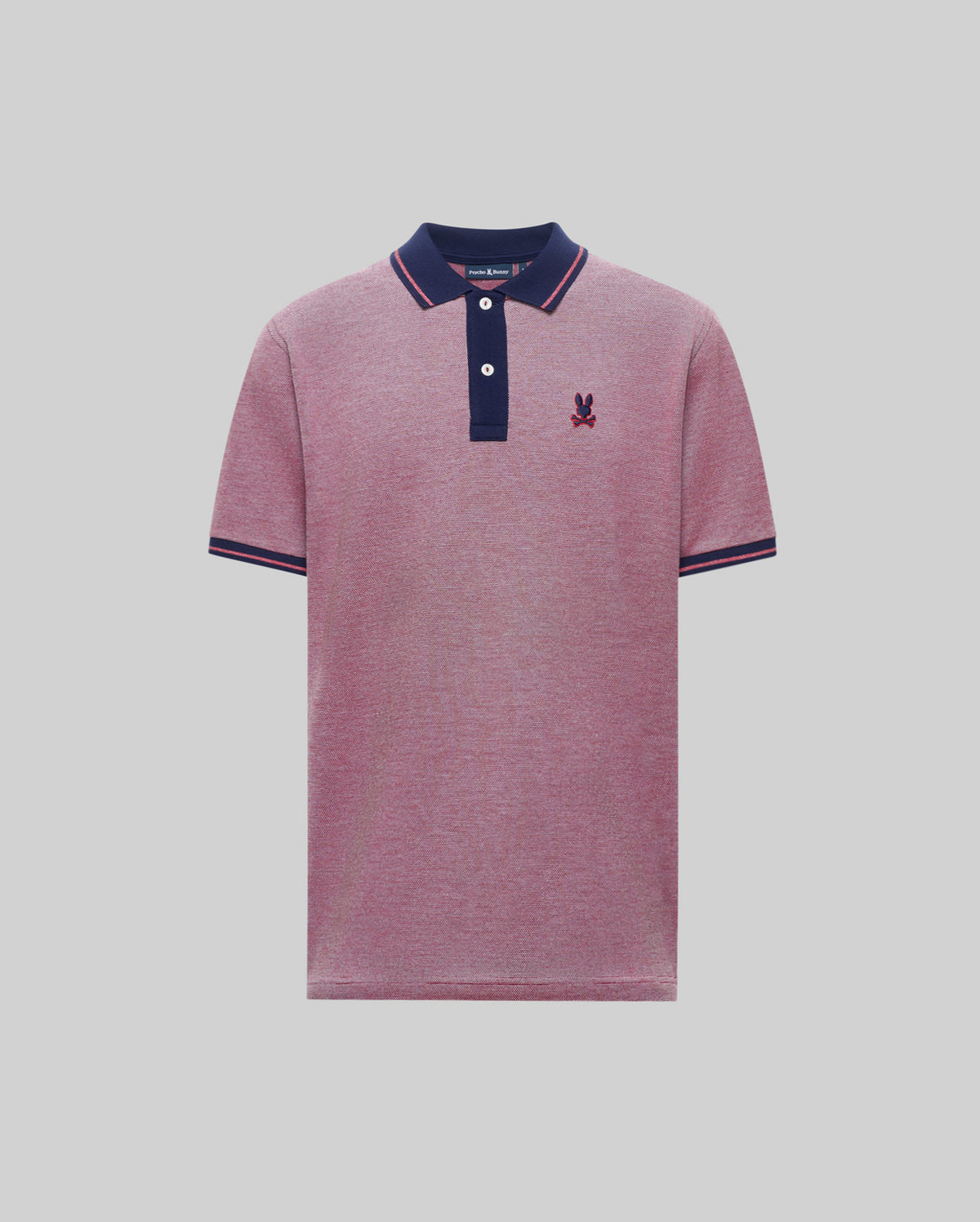 The Psycho Bunny QUINTON TEXTURE PIQUE POLO is a short-sleeved pink shirt with a navy blue, striped collar and sleeve cuffs, two white buttons, and a small embroidered logo on the left chest.