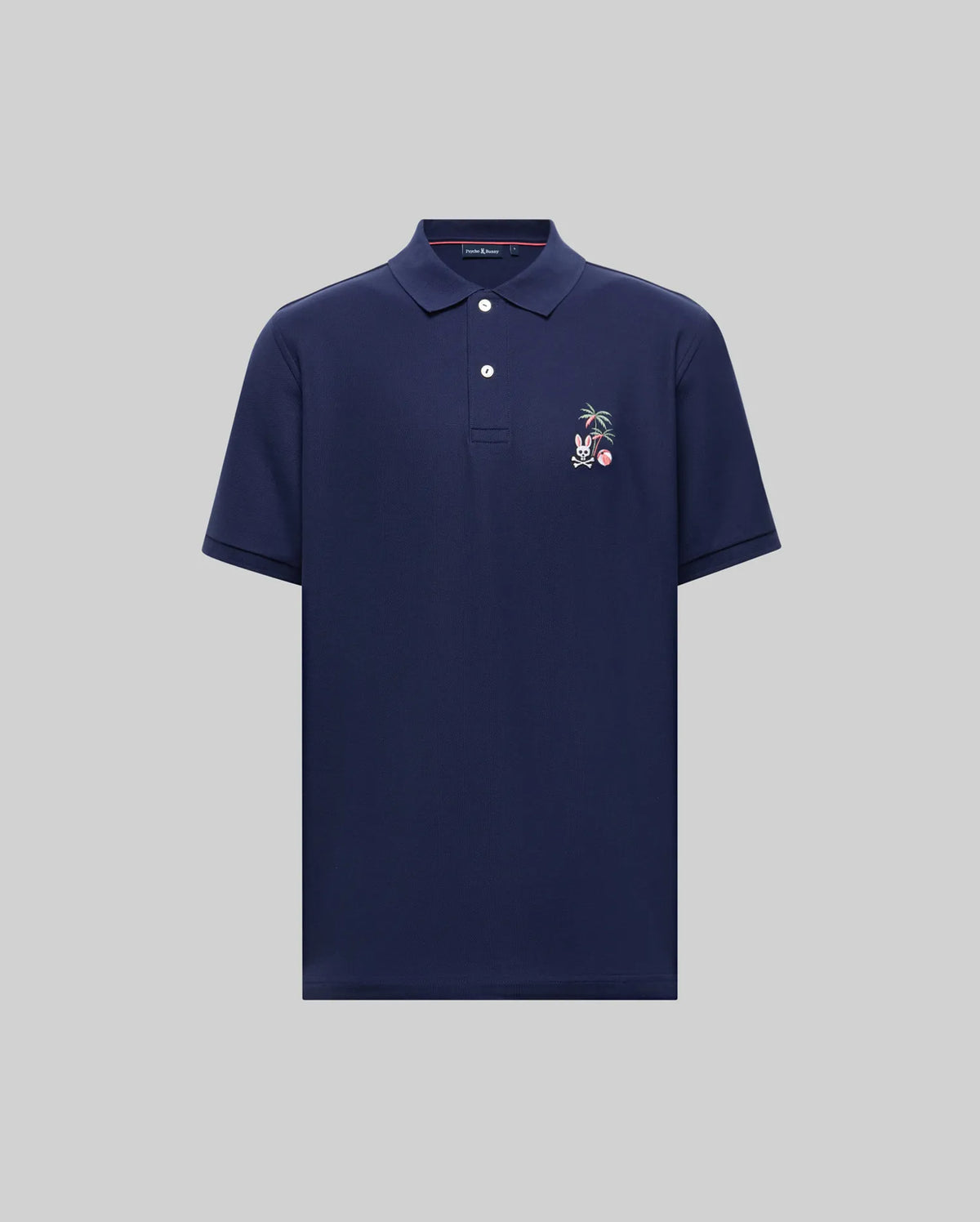 The Psycho Bunny MENS SONNY PIQUE POLO - MT0100094 is a navy blue Pima cotton short-sleeve polo with a collar, three buttons, and an embroidered palm tree and animal on the left chest, shown against a light gray background.